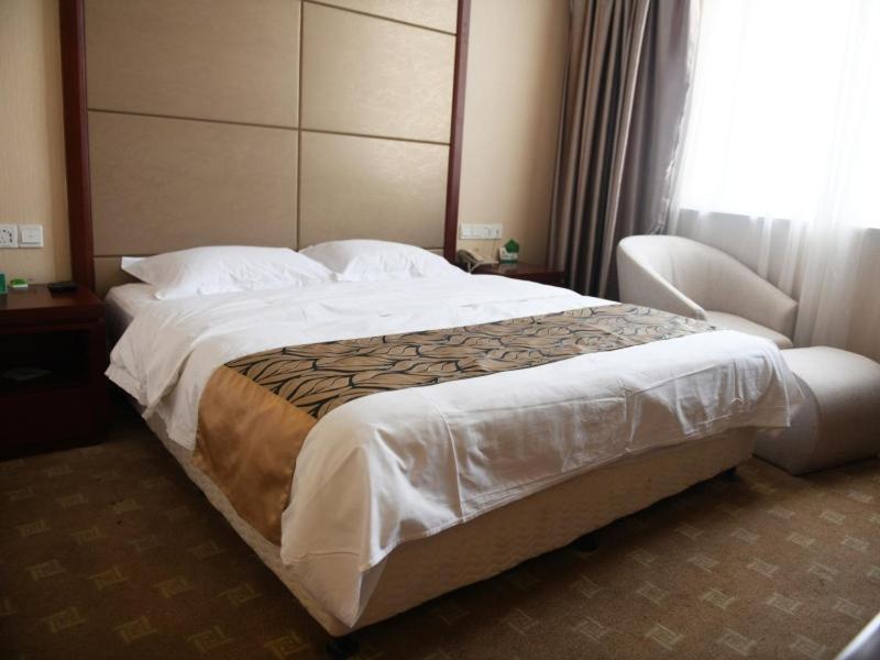 a large bed in a hotel room with a window at GreenTree Alliance Xuzhou Gulou District Sanhuan North Road, Jinju Wuliuwan Hotel in Xuzhou