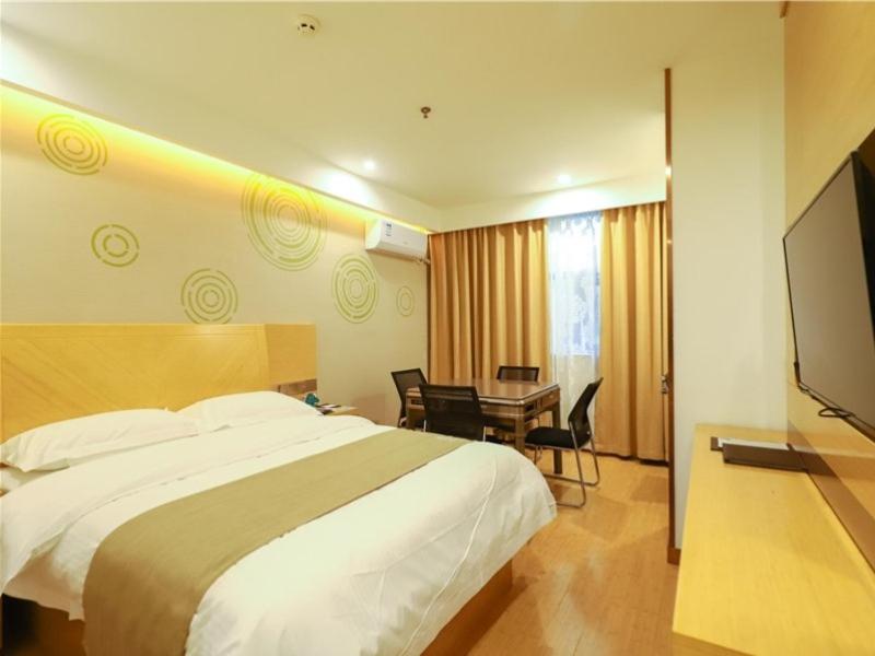 Pokój hotelowy z łóżkiem, biurkiem i telewizorem w obiekcie GreenTree Inn Yichun Development Zone Bus Terminal Express Hotel w mieście Yichun