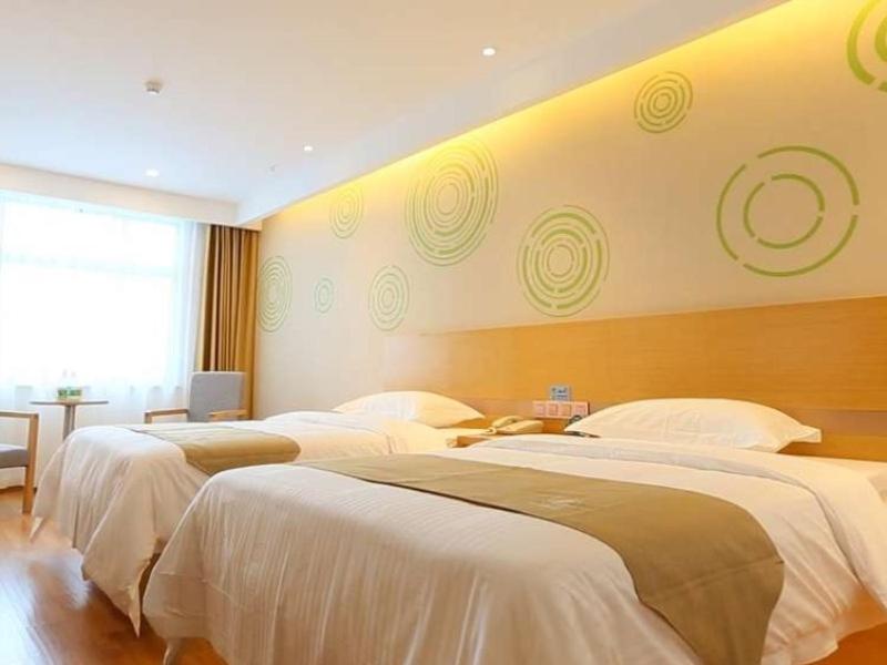Cette chambre d'hôtel comprend 3 lits avec des draps blancs. dans l'établissement GreenTree Inn Taizhou Taixing City Xuanbao Town Zhongyang Road Express Hotel, à Yong'anzhou