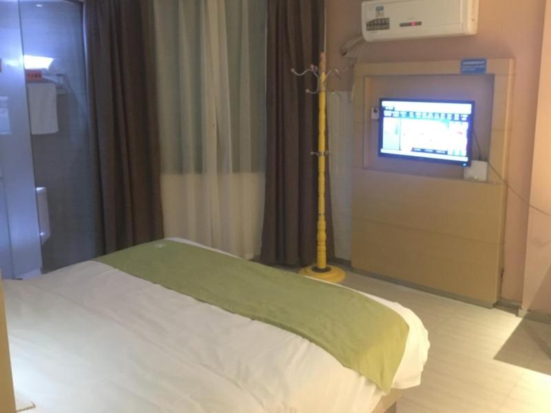 um quarto de hospital com uma cama e uma televisão em GreenTree Alliance Ganzhou City Ningdu County Meijiang Town Sanhuan South Road Hotel em Ningdu