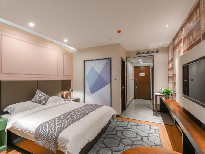 a bedroom with a large bed and a flat screen tv at GME Hefei Fuyang North Road Beicheng Hotel in Hefei