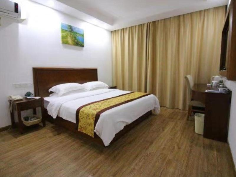a hotel room with a bed and a desk at GreenTree Inn Jiangsu Changshu City Longying Square Express Hotel in Changshu