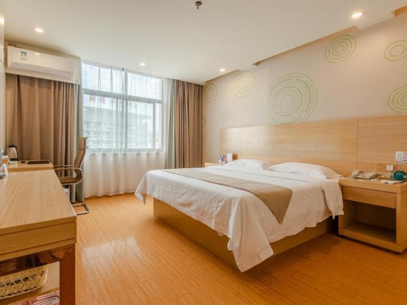 um quarto com uma cama grande e uma janela grande em GreenTree Inn LiuAn Huoshan County Yingjia Avenue County Hospital Express Hotel em Huoshan