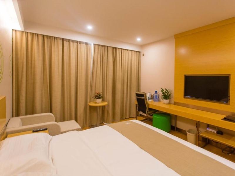 a hotel room with a bed and a desk with a television at GreenTree Inn Xingtai City Neiqiu County 107 National Road Business Hotel in Xingtai