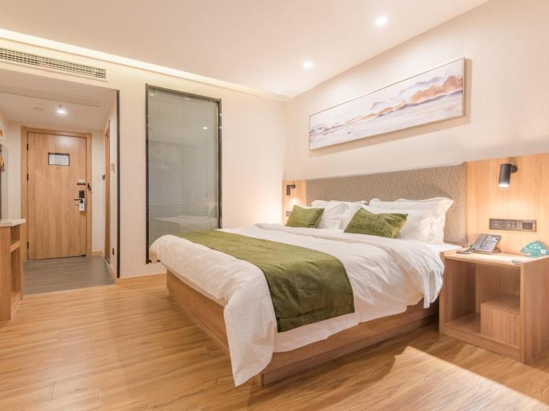 a bedroom with a large bed and a walk in shower at GreenTree Inn Hefei Binhu Shijicheng Hospital Hotel in Hefei