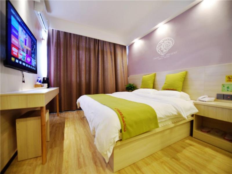 - une chambre avec un grand lit et une télévision à écran plat dans l'établissement Shell Hefei Heping Road Shuguang Cinema East Qili Subway Station Hotel, à Hefei