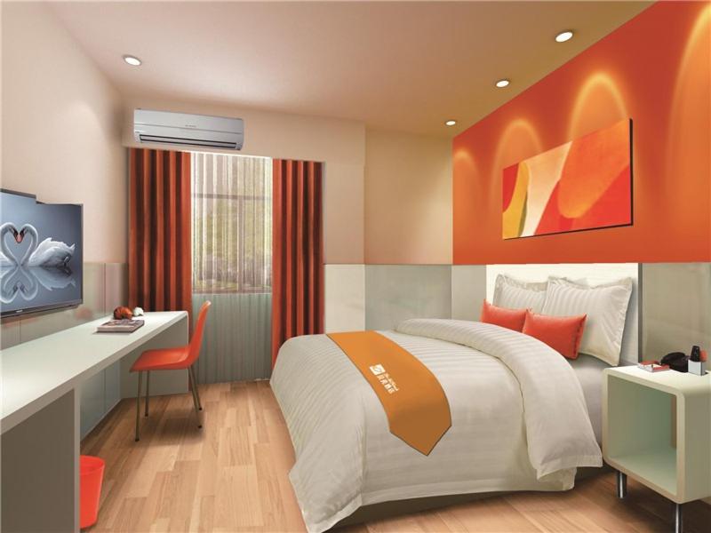 1 dormitorio con 1 cama y escritorio con ordenador en Shell Shijiazhuang City Zhengding International Airport Hotel, en Shijiazhuang