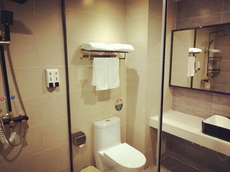 a bathroom with a shower with a toilet and a mirror at GreenTree Alliance Kunming Beijing Road Linyuqiao Subway Station Hotel in Kunming