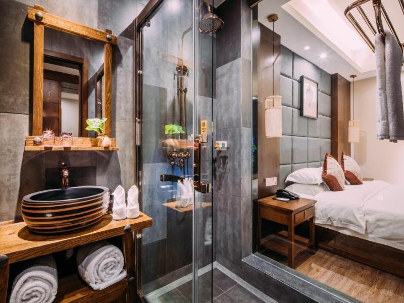 a bathroom with a shower and a sink and a bed at GreenTree Eastern Changzhou Liyang CityTianmu Lake Four Seasons Hotel in Liyang