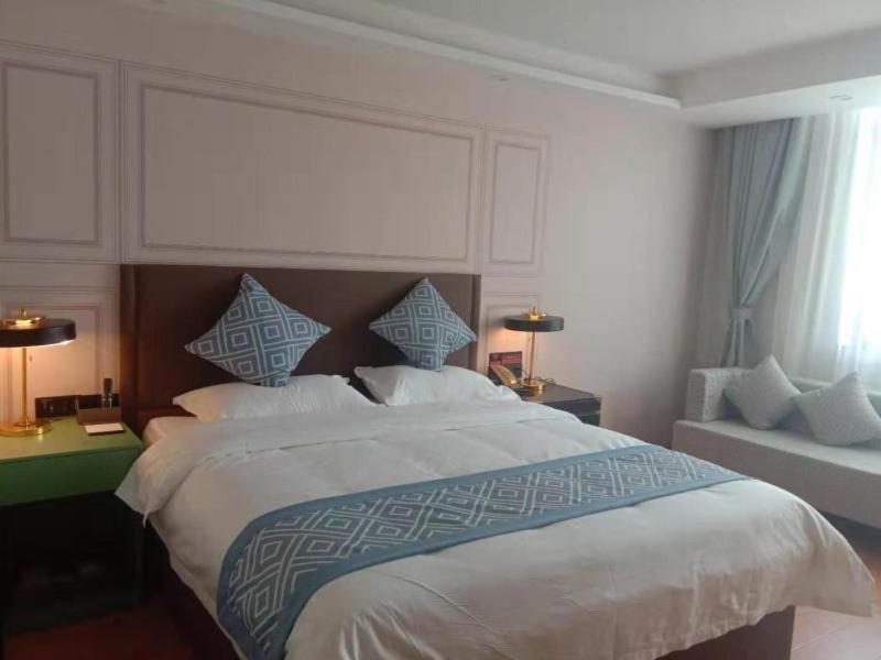 um quarto com uma cama grande e uma janela em Gme Fuyang Guangming South Road Hotel em Fuyang