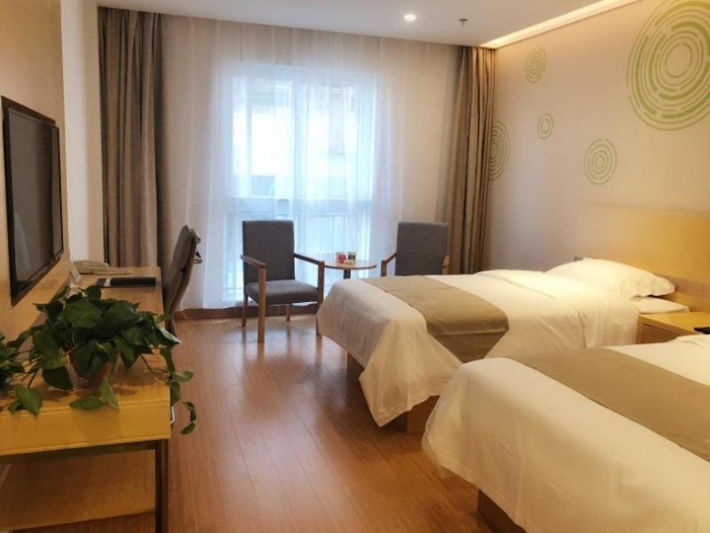a hotel room with two beds and a television at GreenTree Inn Anyang Neihuang District Zaoxiang Road Hotel in Anyang