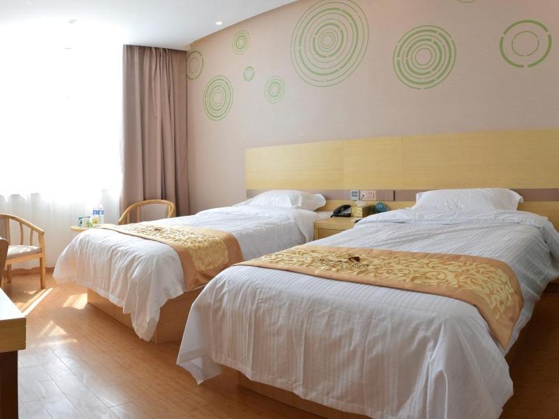 Cette chambre d'hôtel comprend 2 lits avec des draps blancs. dans l'établissement GreenTree Inn Suzhou Yongqiao District Nanxiang Hengtai City Business Hotel, à Suzhou