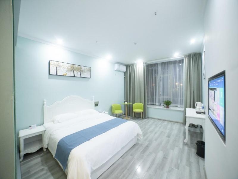 een hotelkamer met een bed en een flatscreen-tv bij Shell Chuzhou North Bus Station Hotel in Chuzhou