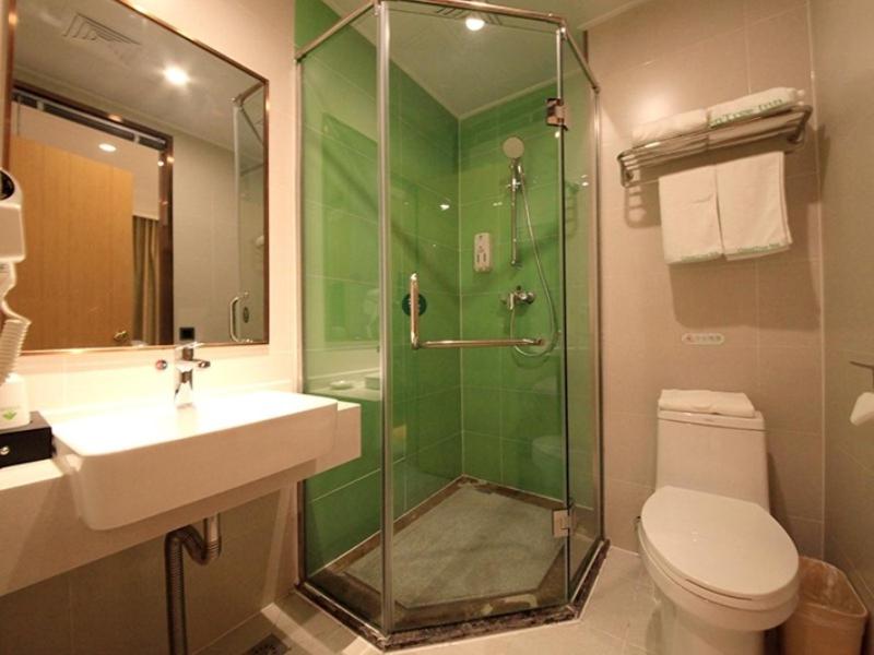 een badkamer met een douche, een toilet en een wastafel bij GreenTree Inn Zhengzhou Gongyi Xinxing Road Business Hotel in Zhengzhou