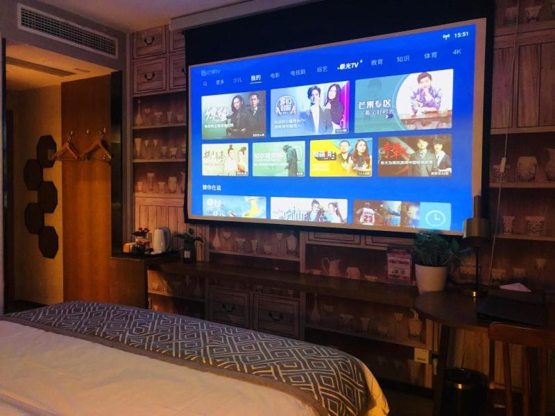 a large flat screen tv in a living room at GME Rizhao Jinan Road Sun Plaza Hotel in Rizhao