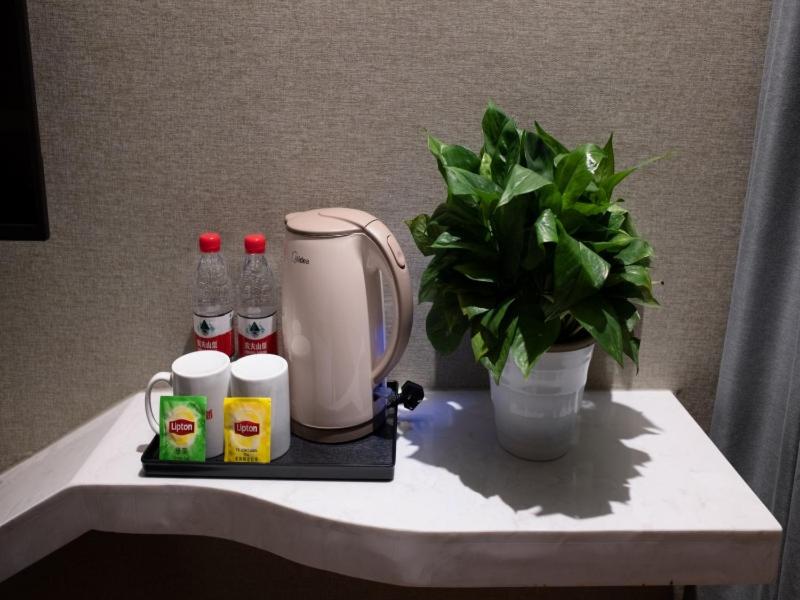 a table with a blender and a potted plant on it at Shell Shanghai Wanda Plaza Wujiaochang Metro Station Hotel in Shanghai