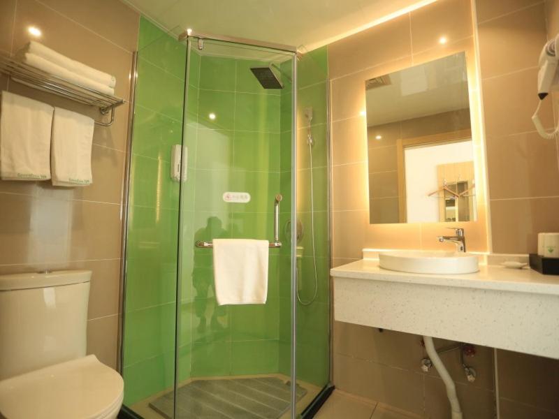 a bathroom with a shower and a toilet and a sink at GreenTree Inn Anqing City Yixiu Government District University City Express Hotel in Anqing