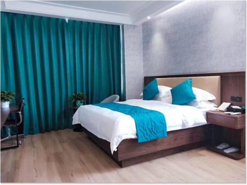 Un pat sau paturi într-o cameră la GreenTree Inn Yinchuan International Trade City Business Hotel