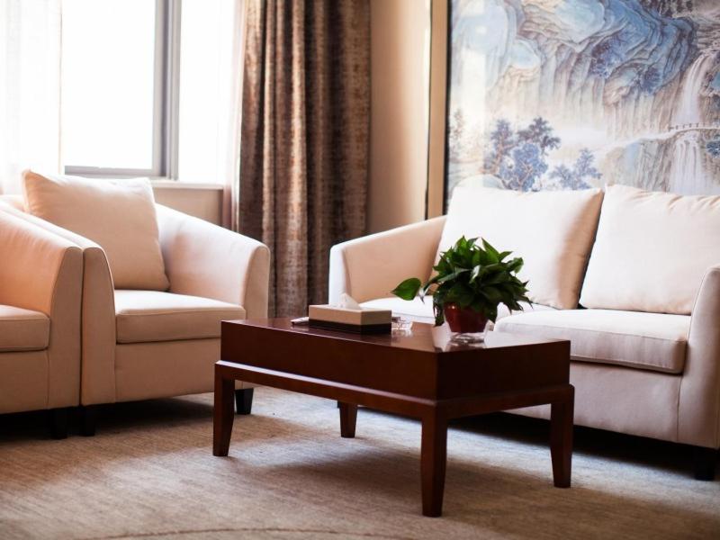 a living room with two couches and a coffee table at GreenTree Eastern Bozhou Jingwan Wealth Centre Hotel in Bozhou