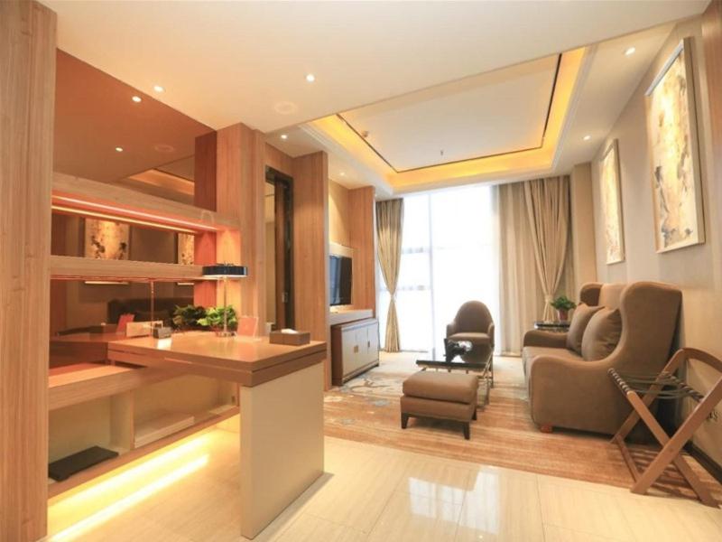 sala de estar con cocina y sala de estar con sofá en GreenTree Eastern Bengbu City Guzhen County Century Hotel en Qiaokou