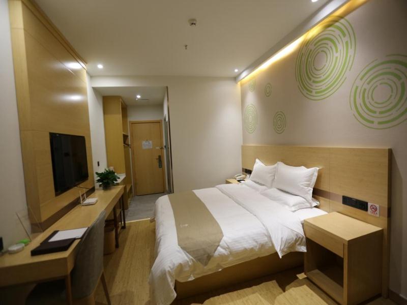 a hotel room with a large bed and a television at GreenTree Inn Dezhou Bus Station Train Station Express Hotel in Dezhou