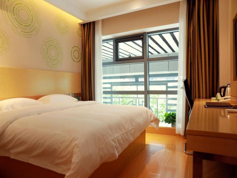 una camera con un letto bianco e una finestra di GreenTree Inn Suzhou Yongqiao District Suma Park Suzhou Avenue High-speed Railway Station Business Hotel a Suzhou