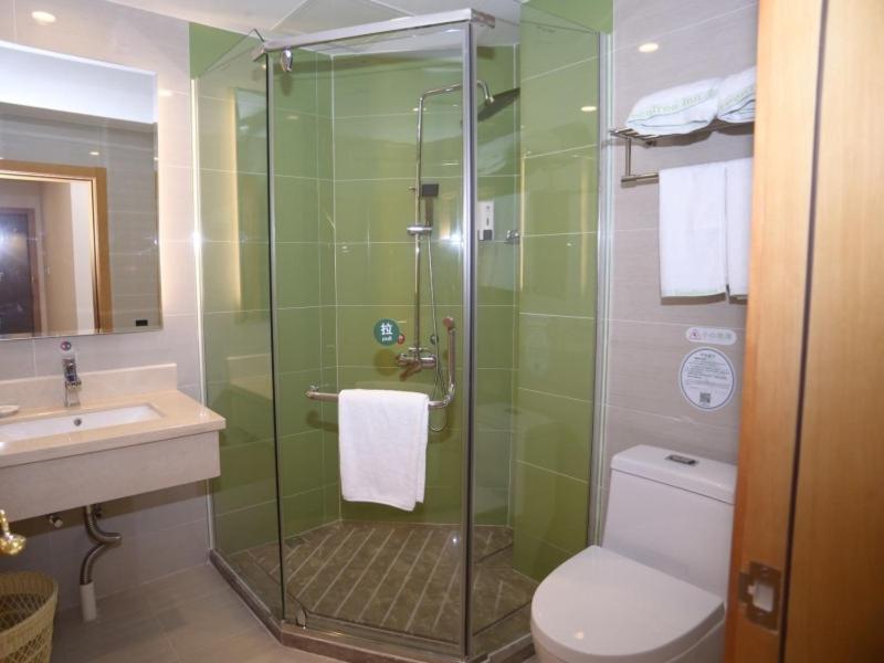 a bathroom with a shower and a toilet and a sink at GreenTree Inn Zhongshan West District Fuhua Road Hotel in Zhongshan