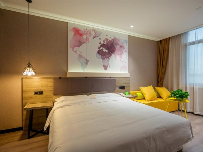 a bedroom with a large white bed in a room at Vatica Wuxi Yixing City Renmin Road Hotel in Yixing