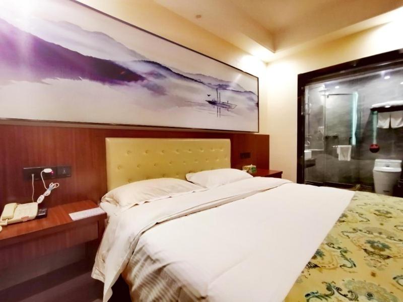 ein Schlafzimmer mit einem großen Bett mit einem großen Gemälde an der Wand in der Unterkunft GreenTree Alliance Changzhou Jintan District Dongmen Street Hotel Hotel in Changzhou