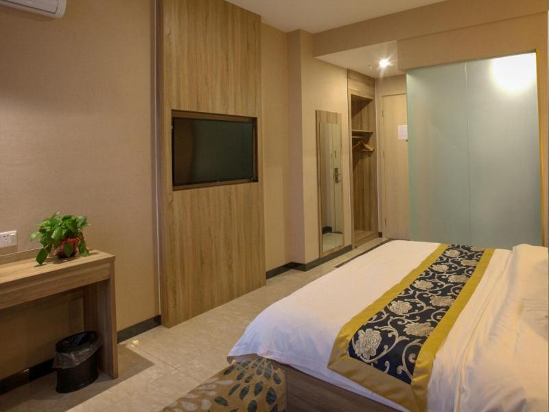 pokój hotelowy z łóżkiem i telewizorem w obiekcie Shell Hefei Changjiang West Road Nangang Subway Station Hotel w mieście Hefei