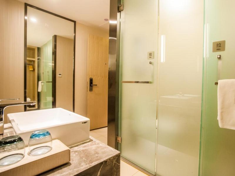 a bathroom with a glass shower and a sink at GreenTree EasternLianyungang Wanda Plaza Hotel in Lianyungang