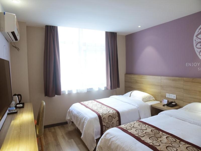 a hotel room with two beds and a window at Shell Hefei Qingyang North Road 901 Hospital Hotel in Hefei