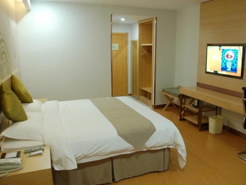 - une chambre avec un lit, un bureau et une télévision dans l'établissement GreenTree Inn Linyi Shuixian Bus Station Business Hotel, à Yishui