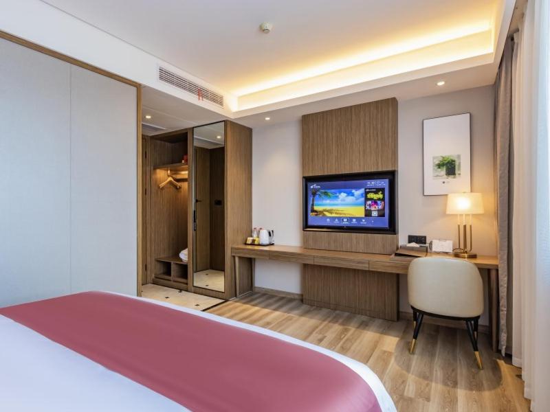 a hotel room with a bed and a television at Gya Jiaxing City Haiyan County Chang'an South Road Lishi Plaza Hotel in Jiaxing