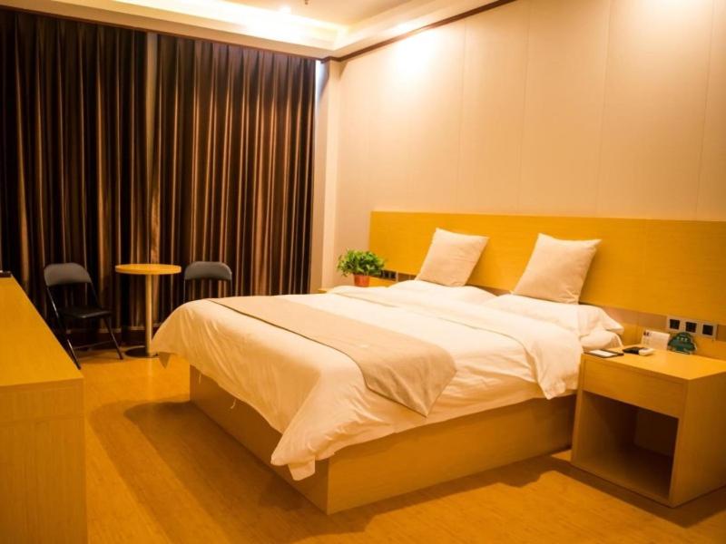 ein Schlafzimmer mit einem großen Bett mit einem gelben Kopfteil in der Unterkunft GreenTree Inn Qinhuangdao Lulong County North Gate Road Express Hotel in Qinhuangdao