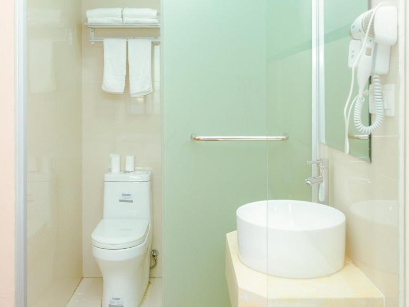 een witte badkamer met een toilet en een wastafel bij Shell Jiaxing Jiashan Shenyou Road Hotel in Jiaxing
