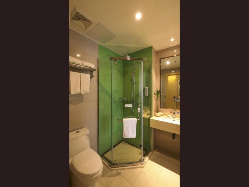 a bathroom with a toilet and a shower and a sink at GreenTree Inn Wuxi Rongchuang cultural Tourism City Nanquan Town Business Hotel in Wuxi