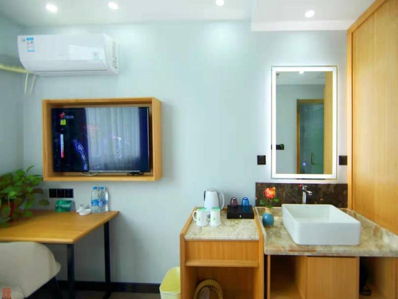 een badkamer met een wastafel en een spiegel bij GreenTree Inn Wuxi Jiangyin Changjing Town Selected Hotel in Wuxi