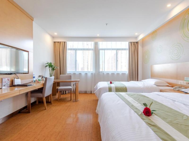 a hotel room with two beds and a desk and a deskablish at GreenTree Inn Hefei Shushan District Binhu Qiancheng Business Hotel in Hefei