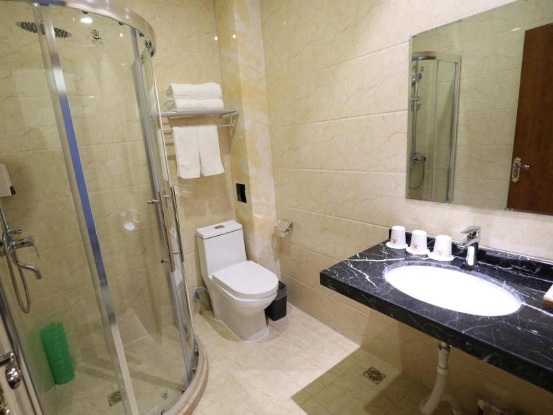 ein Bad mit einem WC, einem Waschbecken und einer Dusche in der Unterkunft Shell Taiyuan City Xiaodian District Zhenwu Road Hotel in Taiyuan