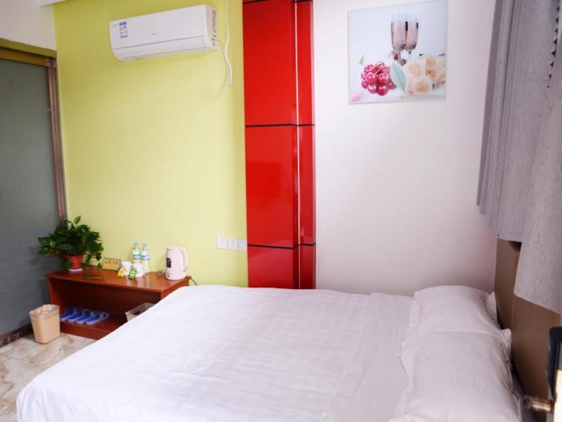 Schlafzimmer mit einem weißen Bett und roten Schränken in der Unterkunft Shell Jinan Zhangqiu District Diao Town Center Street Hotel in Jinan