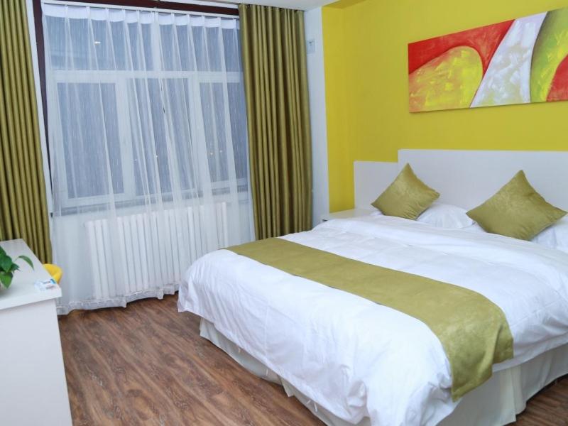 a bedroom with a large white bed and a window at Shell Chengde Longhua County Xingzhou Road Hotel in Chengde