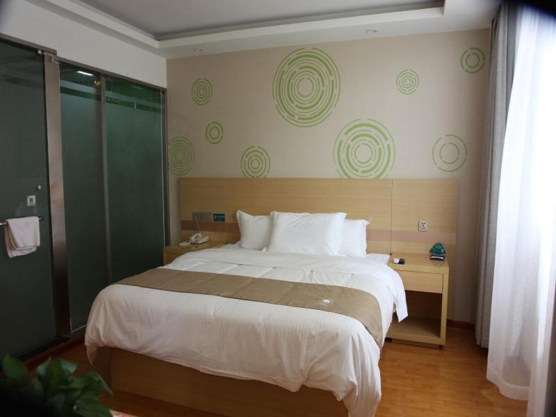 a bedroom with a large bed in a room at GreenTree Inn Zaozhuang High Speed Rail Station Express Hotel in Taozhuang