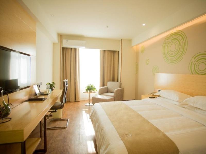 una camera d'albergo con un grande letto e una scrivania di GreenTree Inn Jinan Tangye Express Hotel a Jinan