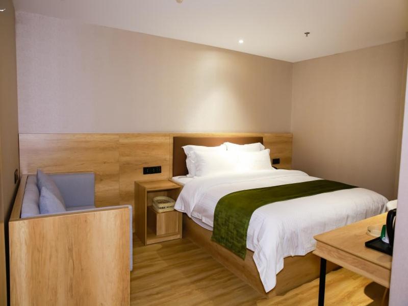 1 dormitorio con 1 cama blanca grande y escritorio en GreenTree Inn Ankang Chengpeng Mechatronics CityBusiness Hotel en Xilingjing