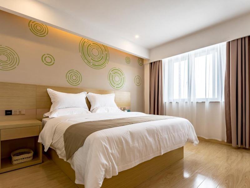 a bedroom with a large bed and a window at GreenTree Inn Changzhou Zouqu Town Tai fu Times Square Zhenzhong Road Express Hotel in Changzhou