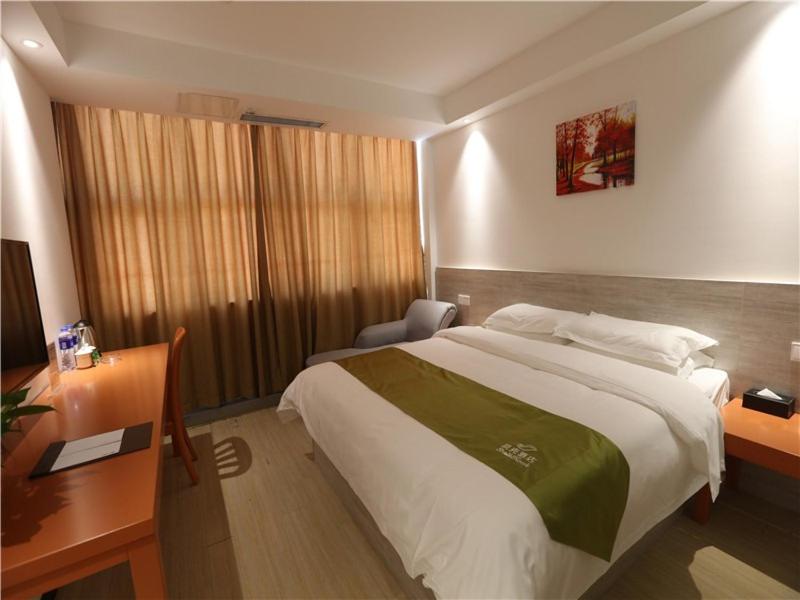 um quarto com uma cama grande, uma secretária e uma cama lateral. em Shell Hefei Economic Development Zone Mingzhu Square Jinzhai South Road Hotel em Shibagang