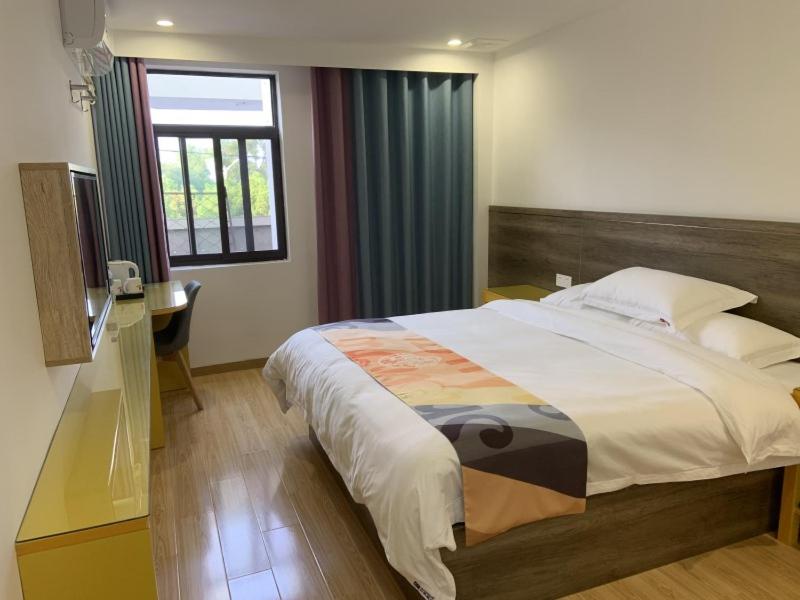 sypialnia z dużym łóżkiem i oknem w obiekcie Shell Liu'an Wanxi Avenue International Motor City Hotel w mieście Lu'an