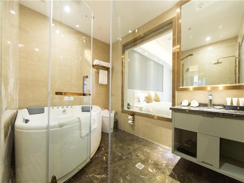 uma casa de banho com uma banheira, um lavatório e um espelho. em GreenTree Eastern Yibin Yijian Road New City Plaza Hotel em Baixi