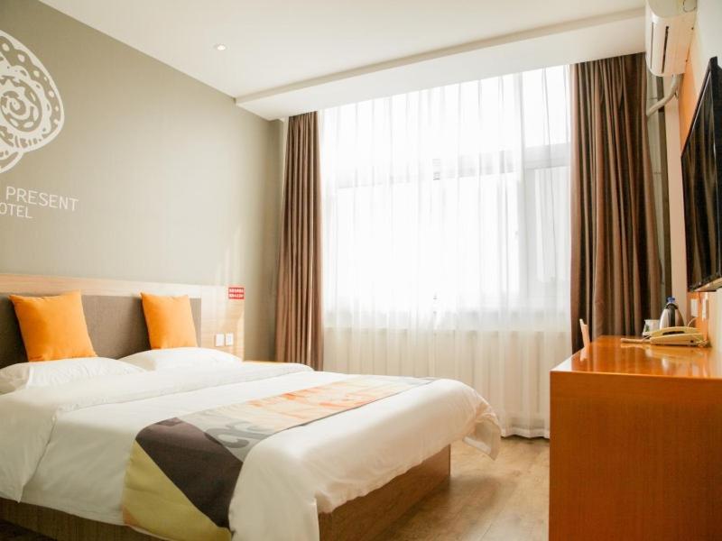 a hotel room with a bed and a window at Shell Tangshan Caofeidian District Xinghai Mingdu Plaza Hotel in Tangshan